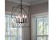 Stylish modern black chandelier illuminates the space and complements the room's design with natural light from the nearby windows at 921 Bradenville Ln, Winter Garden, FL 34787