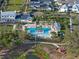 Aerial shot of the community pool, lush landscaping, palm trees, lounge chairs, and outdoor seating areas at 921 Bradenville Ln, Winter Garden, FL 34787