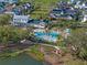 Aerial view featuring a luxurious community pool with palm trees, lounge chairs, and meticulously landscaped grounds at 921 Bradenville Ln, Winter Garden, FL 34787