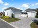 View of a large property with 2 garages, paver driveway, green grass, and beautiful blue skies at 921 Bradenville Ln, Winter Garden, FL 34787