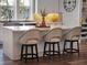 Kitchen island featuring a white countertop with seating for three, plus white cabinetry and hardwood floors at 921 Bradenville Ln, Winter Garden, FL 34787