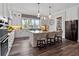 Bright, open kitchen with an island, pendant lighting, hardwood floors and modern white cabinetry and stainless steel appliances at 921 Bradenville Ln, Winter Garden, FL 34787