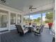 Stylish screened-in porch with comfortable seating, ceiling fan, and view of the green neighborhood at 921 Bradenville Ln, Winter Garden, FL 34787