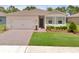 Charming single-story home boasts lush green lawn, brick driveway, and neutral exterior paint at 1511 Lyonsdale Ln, Sanford, FL 32771