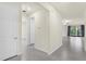 Hallway with light walls and gray tile flooring leading to open living space with sliding glass doors at 1511 Lyonsdale Ln, Sanford, FL 32771