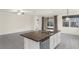 Open kitchen boasts a center island with granite countertop, stainless steel appliances, and tile flooring at 1511 Lyonsdale Ln, Sanford, FL 32771