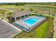 An aerial view showcases a community pool surrounded by lounge chairs, palm trees, and landscaped areas at 1511 Lyonsdale Ln, Sanford, FL 32771