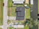 Aerial view of a home with a black roof, featuring a fenced yard and canal access at 5208 Oakdale Rd, Haines City, FL 33844