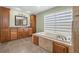 An elegant bathroom featuring a soaking tub, and dual sinks with a vanity at 5208 Oakdale Rd, Haines City, FL 33844