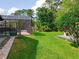 Manicured backyard with lush lawn and screen enclosed pool at 1007 Gammage Pt, Oviedo, FL 32765