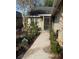 Charming single-story home with a walkway, colorful flower beds, and a screened-in front porch at 1034 Weathered Wood Cir, Winter Springs, FL 32708