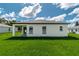 A spacious backyard view features a freshly mowed lawn and a covered patio adjacent to the home at 12950 Sw 38Th Cir, Ocala, FL 34473