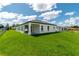 Expansive green backyard showcasing the home's rear exterior and a covered patio area for relaxing outdoors at 12950 Sw 38Th Cir, Ocala, FL 34473