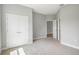 This bedroom features plush carpet and double doors to a closet at 12950 Sw 38Th Cir, Ocala, FL 34473
