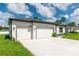Side view of single story home with three-car garage and neutral color scheme at 12950 Sw 38Th Cir, Ocala, FL 34473
