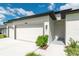 Up close, a well-maintained lawn leads to this property's inviting front entrance and three-car garage at 12950 Sw 38Th Cir, Ocala, FL 34473