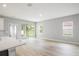 Bright living room with wood-look flooring and a sliding glass door to the backyard at 12950 Sw 38Th Cir, Ocala, FL 34473