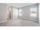 Spacious primary bedroom with two windows, a tray ceiling, and carpeted floors at 12950 Sw 38Th Cir, Ocala, FL 34473
