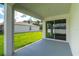View of a covered patio with sliding glass doors and a well-maintained lawn, perfect for outdoor entertaining at 12950 Sw 38Th Cir, Ocala, FL 34473