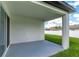 The covered patio has gray painted concrete and leads out to the green grass in the backyard at 12950 Sw 38Th Cir, Ocala, FL 34473