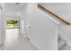 Bright hallway featuring tile flooring and a staircase with a wooden handrail leading upstairs at 172 River Front Way, Edgewater, FL 32141