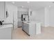 This modern kitchen showcases gray cabinets and an island with a sink and dishwasher at 174 River Front Way, Edgewater, FL 32141