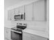 Updated kitchen boasts gray cabinets and stainless steel appliances at 174 River Front Way, Edgewater, FL 32141