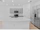 Bright kitchen with large island, stainless steel appliances, and gray cabinetry at 174 River Front Way, Edgewater, FL 32141