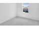 Bright bedroom with carpet floors and a window providing natural light and neighborhood views at 176 River Front Way, Edgewater, FL 32141