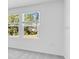 Bedroom features two large windows overlooking a green space and forest view at 176 River Front Way, Edgewater, FL 32141