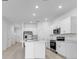 Bright kitchen with stainless steel appliances, white cabinets and a large center island at 176 River Front Way, Edgewater, FL 32141