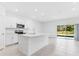 Kitchen with island, sink, and stainless appliances adjacent to a spacious living room at 176 River Front Way, Edgewater, FL 32141
