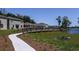 Community walkway with beautiful landscaping, leading to residences near a serene pond at 176 River Front Way, Edgewater, FL 32141