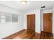 Bedroom featuring hardwood floors and a built-in closet with wood panel doors at 1825 Baldwin Dr, Orlando, FL 32806