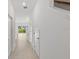 A long and well-lit hallway with neutral colored walls and white doors at 184 River Front Way, Edgewater, FL 32141