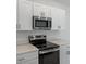 Close-up of kitchen featuring stainless steel microwave and oven at 184 River Front Way, Edgewater, FL 32141