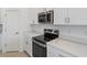 Bright kitchen featuring white cabinets, stainless steel appliances, and stone countertops at 184 River Front Way, Edgewater, FL 32141