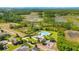 Aerial view of community pool, playground, and surrounding lush green landscapes with a pond at 256 Whirlaway Dr, Davenport, FL 33837