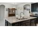 Granite kitchen island with stainless steel sink, perfect for food preparation and entertaining in style at 256 Whirlaway Dr, Davenport, FL 33837