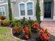 Lush landscaping featuring vibrant red flowers and manicured greenery surrounds the entrance of this lovely home at 256 Whirlaway Dr, Davenport, FL 33837