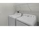 Functional laundry area equipped with a white washer and dryer set, and wire shelving above at 256 Whirlaway Dr, Davenport, FL 33837
