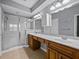 Bathroom featuring dual sinks, a glass shower, and a large mirror above the vanity at 8316 Quimby Cir, Davenport, FL 33896
