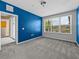 Spacious bedroom with a vibrant accent wall, carpet flooring, and a sliding glass door at 8316 Quimby Cir, Davenport, FL 33896