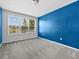 Bright bedroom with a blue accent wall, plush carpeting, and scenic outdoor views from its window at 8316 Quimby Cir, Davenport, FL 33896