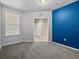 Carpeted bedroom with gray walls, a blue accent wall, and a view to the hallway at 8316 Quimby Cir, Davenport, FL 33896