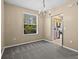 Neutral dining room with carpet, chandelier and large window providing view to the yard at 8316 Quimby Cir, Davenport, FL 33896