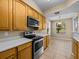 Modern kitchen with stainless steel appliances, light wood cabinets, and a tiled floor at 8316 Quimby Cir, Davenport, FL 33896