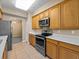 Well-lit kitchen featuring stainless steel appliances, ample countertop space, and light wood cabinetry at 8316 Quimby Cir, Davenport, FL 33896