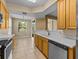 Modern kitchen with stainless steel appliances, light wood cabinets, and tiled floor at 8316 Quimby Cir, Davenport, FL 33896