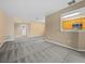 Large living room area with neutral walls and plush carpeting with an eat-in kitchen bar at 8316 Quimby Cir, Davenport, FL 33896